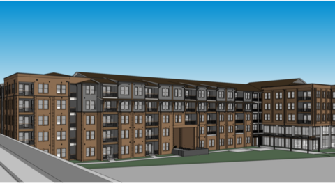 A long brown and gray apartment complex with glass at one side. 