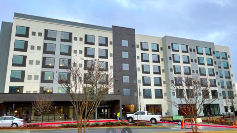 A white and brown hotel under gray skies. 