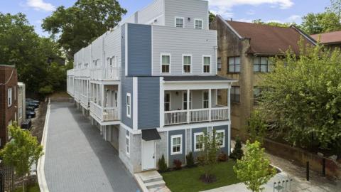 A new townhome project in white and gray on an Atlanta street with trees. 