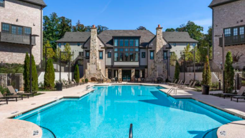 A large suburban home development situated around a blue pool. 
