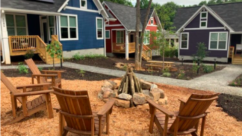 A row of colorful tiny homes built outside Atlanta with trees and pathways. 