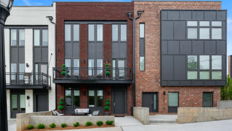 A row of townhome buildings in Atlanta with blue skies overhead. 
