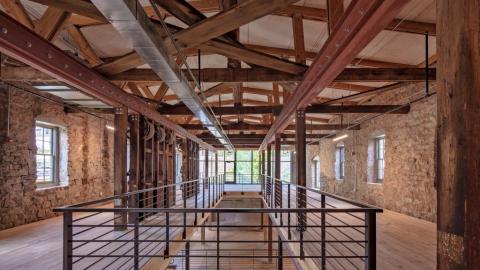 A view of an old mill converted to offices with stone walls. 