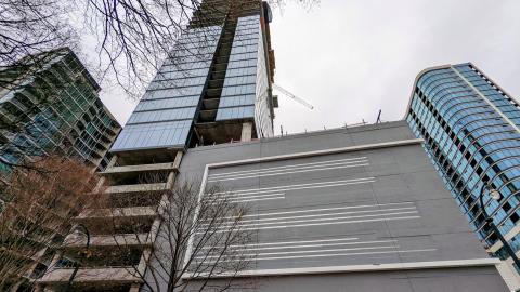A photo of a tall glassy building against a gray sky in Atlanta. 