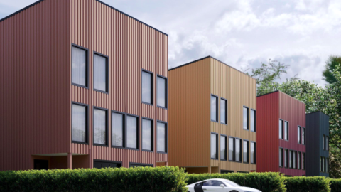 A row of modern new townhomes being built along a busy road in Atlanta. 