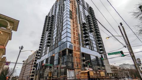 A photo of a glassy high rise building in downtown Atlanta against gray skies.