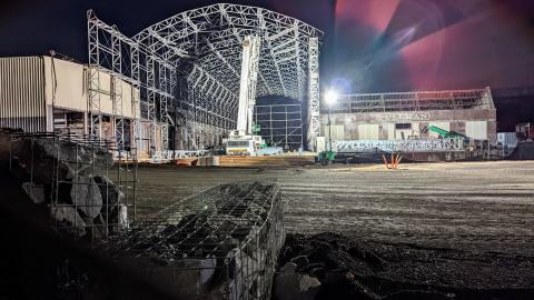 A nighttime photo of a large stadium structure taking shape in a factory setting in Atlanta. 