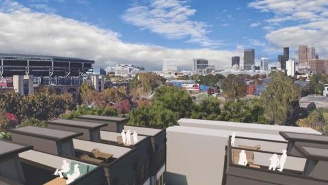 A rendering of townhomes built next to a large baseball stadium under blue skies near downtown Atlanta. 