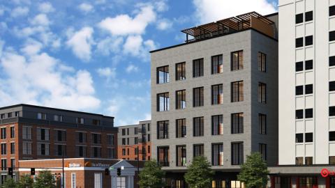 A rendering of condos shown among other mid-rise buildings under a blue sky.