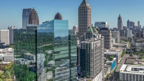 A drone image of a new tall development coming together in Atlanta under blue skies with green trees around. 