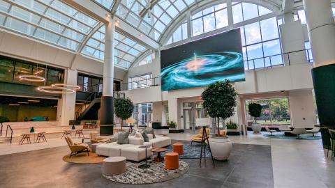 A photo of a large office building with many windows that's been renovated in a walkable district of Atlanta. 