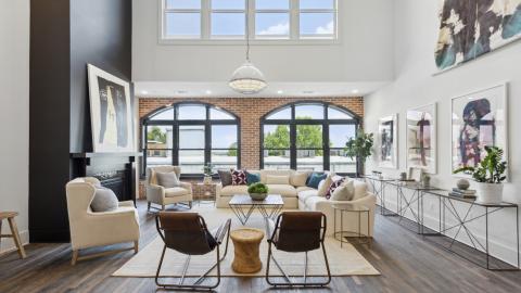 A photo of a large white condo with much art on the walls and brick accents in downtown Atlanta.