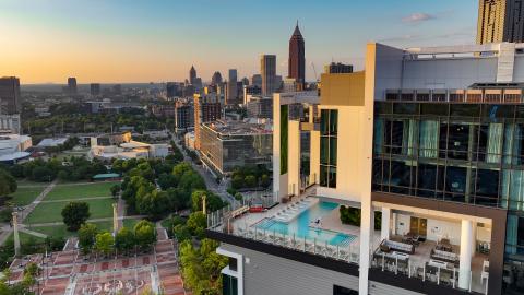 A photo of a large new white resort building under blue skies in downtown Atlanta. 