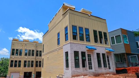 A photo of two townhome buildings built on red clay under blue skies in Atlanta. 