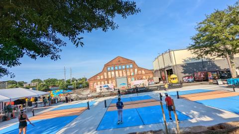 A photo of a large former industrial site where buildings have been restored and new restaurants are being built. 