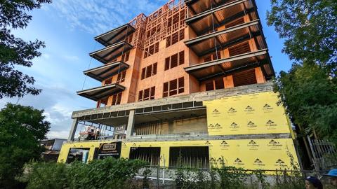 A photo of a condo building topped out under blue skies with wispy clouds in Atlanta. 