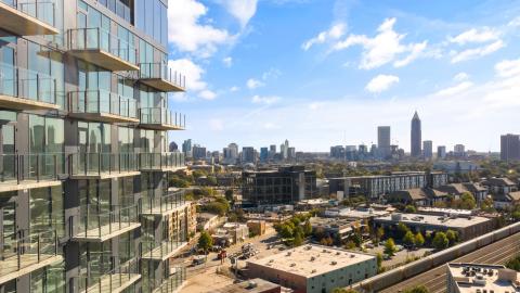 A photo of a glassy building under blue skies with Atlanta in the background. 