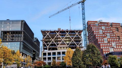 A photo of a several buildings under construction near cranes under blue skies in Atlanta. 