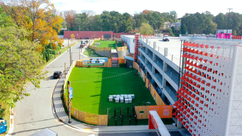 A photo of a former warehouse district with new offices and lawns and shops, plus new apartments in a white building.