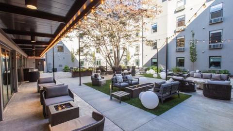 A photo of a former red roof inn reborn as a boutique hotel with floral wallpaper and a large courtyard in Atlanta. 