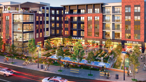 A large brick and glass development under blue skies in Atlanta with a corner plaza in the front with fountains, under construction.