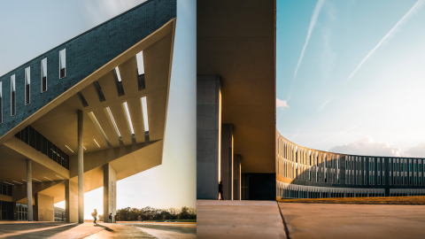 A long s-shaped new high school with thick columns and a white modern interior shown under blue skies, with many trees around.