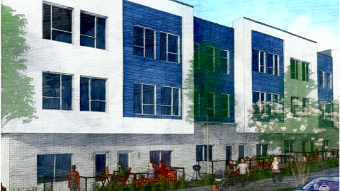 An image of a townhome site near a busy Atlanta road with trees in front, under blue skies.