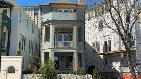 An image showing rows of large and fancy new homes being built near large roads in the middle of Atlanta. 