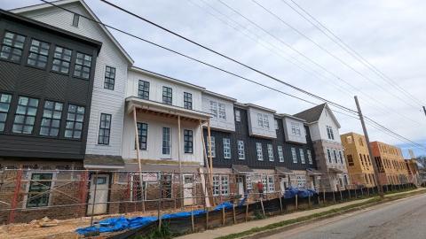 A large housing development fronting a busy street under gray skies in Atlanta. 