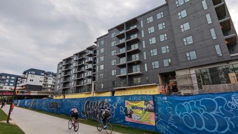 A photo of a large black building beside a wide biking and walking trail under gray skies in Atlanta. 