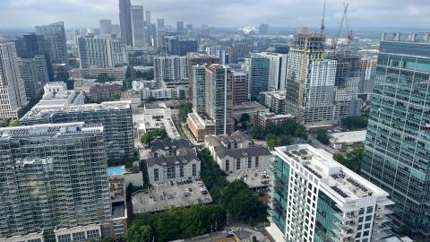 A view across many skyscrapers in a city with clouds over it. 