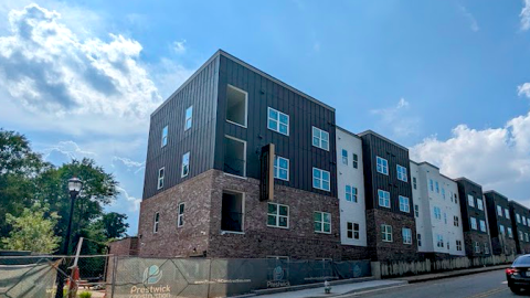 An image of a new brick and metal building under blue skies near a wide road in Atlanta.