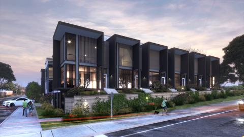 An image of modern-style black townhomes under construction near a  wide street and trees in Atlanta. 