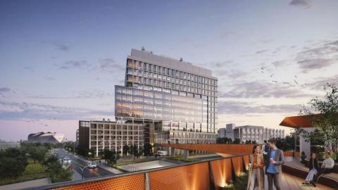 A rendering showing a glassy new building under blue and purple skies near a large bridge. 