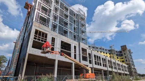 A photo of a large concrete and steel structure over a wide road under blue skies in Atlanta. 