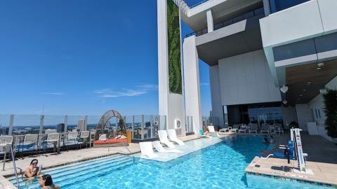 A photo of a modern new condo building with blue-themed rooms and a pool on the 19th floor.