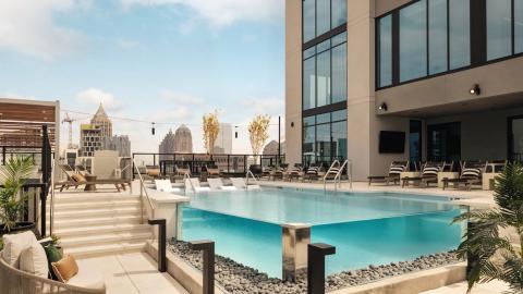 A fancy new white and brown tower for students in Midtown Atlanta under blue skies with classic interiors and pool on the roof.