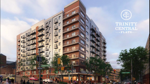 A rendering of an affordable housing complex in white and orange under blue cloudy skies. 
