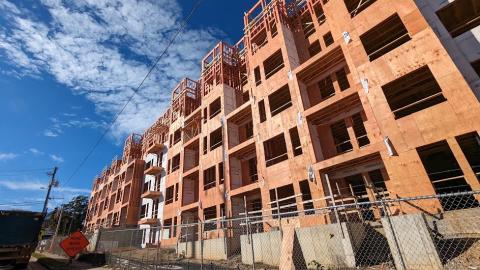 An image of a 400-unit apartment complex with two parts rising over two wide roads in Atlanta under blue skies.