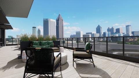 An image showing a large block new apartment complex near transit lines and wide roadways in Atlanta, under blue skies.