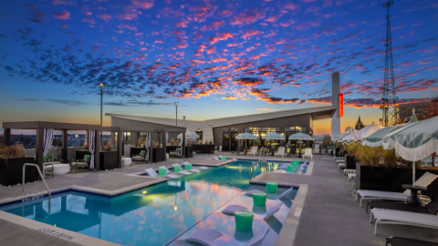 A photo of a new apartment complex in Atlanta with a pool on the roof and wild interior designs, near many downtown buildings. 