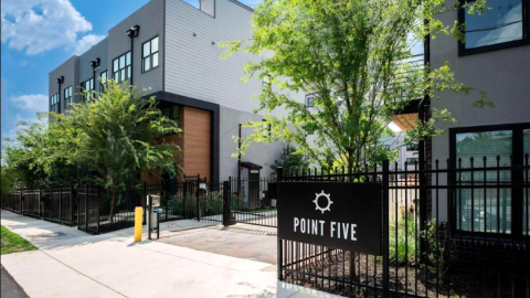 An image showing a modern-style townhome site near rows of trees and other houses under blue skies south of downtown Atlanta.