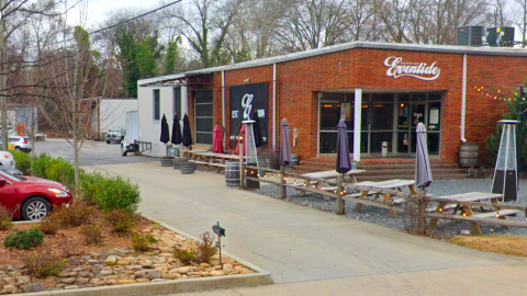 An image of a building where a motorcycle club wants to set up shop in a warehouse district, with a brick-built brewery in front.
