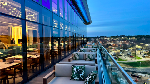 A photo of a large new modern hotel near parking lots and wide streets with fancy contemporary interiors. 