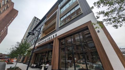 A photo of a large new building made from timber with a Pottery Barn retailer at the base and a green roof.