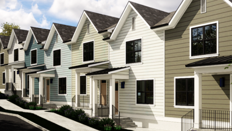 A row of modern style townhomes under blue cloudy skies next to a parking lot and wide street on a lot on Atlanta's Southside. 