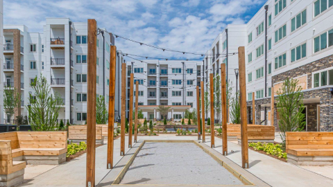 A white and stone new apartment complex with an internal courtyard and parking lots in southwest Atlanta.