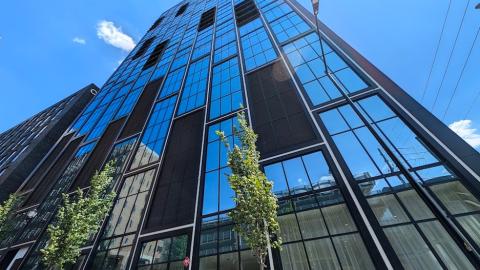A new high-rise in Midtown Atlanta with white and black checkerboard exteriors and balconies and a modern interior with large lobbies and a pool and white-walled apartments. 