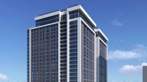 A large blocky apartment building with white details and a lot of glass on the facades under blue skies in Midtown Atlanta.