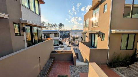 A photo of many beige and white buildings under blue skies near many steps in a new town south of Atlanta.
